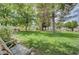 Lush backyard with mature trees, green grass, and seating for outdoor enjoyment at 4998 Schumann Dr, Las Vegas, NV 89146