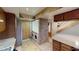 Laundry area with stacked washer and dryer, tile floors, and wood door near kitchen at 4998 Schumann Dr, Las Vegas, NV 89146