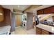 Laundry room featuring granite countertops and tile floors, adjacent to kitchen and entry to stairs at 4998 Schumann Dr, Las Vegas, NV 89146