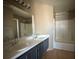 A bright bathroom featuring a double sink vanity with a shower and tub at 5128 Sandstone Dr, Las Vegas, NV 89142