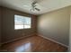 Bedroom with hardwood floors, ceiling fan, and ample natural light from a large window at 5128 Sandstone Dr, Las Vegas, NV 89142