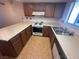 Well-lit kitchen featuring wood cabinets, gas range, and neutral countertops at 5199 Caliente St # 64, Las Vegas, NV 89119