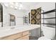 Bathroom featuring a long vanity with double sinks, black shelving, and tile floors at 5332 Desert Blossom Rd, Las Vegas, NV 89107