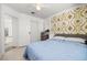 Bedroom featuring light wood floors, a ceiling fan, and an elegant gold-patterned accent wall at 5332 Desert Blossom Rd, Las Vegas, NV 89107