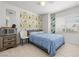 Bedroom featuring light wood floors, a ceiling fan, and an elegant gold-patterned accent wall at 5332 Desert Blossom Rd, Las Vegas, NV 89107