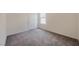 A small bedroom features neutral carpeting, a window, and a door at 5927 Coja St, Las Vegas, NV 89113