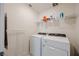 Efficient laundry room with modern washer and dryer, plus convenient shelving for supplies at 5927 Coja St, Las Vegas, NV 89113