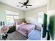 Cozy bedroom with a ceiling fan, window with blinds, and comfortable bed at 6021 Vivanco St, North Las Vegas, NV 89081