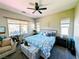 Comfortable bedroom featuring a ceiling fan, a cozy bed with blue bedding, and natural light at 6021 Vivanco St, North Las Vegas, NV 89081
