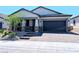 Charming single-story home featuring a two-car garage, stone accents, and a well-manicured front yard at 6021 Vivanco St, North Las Vegas, NV 89081