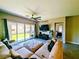 Comfortable living room featuring a ceiling fan, a large sectional sofa, and sliding glass doors at 6021 Vivanco St, North Las Vegas, NV 89081
