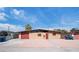 Charming home with a desert landscape featuring a red door and garage at 6112 Fairwood Cir, Las Vegas, NV 89107