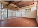 Large covered patio with brick flooring, wood beamed ceiling, and many windows with natural light at 6112 Fairwood Cir, Las Vegas, NV 89107