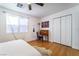 Bedroom features a ceiling fan, hardwood floors, a large bed, a desk, and a closet at 632 Monument Point St, Henderson, NV 89002