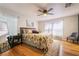Bright main bedroom features hardwood floors, a ceiling fan, and natural light from the windows at 632 Monument Point St, Henderson, NV 89002
