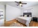 Bedroom features a ceiling fan, hardwood floors, a large bed, and bedside tables at 632 Monument Point St, Henderson, NV 89002