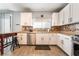The well-lit kitchen features white cabinetry, stainless steel appliances, and a breakfast bar seating area at 632 Monument Point St, Henderson, NV 89002