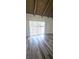 Vaulted bedroom featuring wood-look floors, white walls, and sliding glass door at 708 Fernwood Ln, Las Vegas, NV 89169