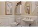 Charming powder room with decorative wall paneling, elegant fixtures, and tasteful decor at 7331 Abundant Harvest Ave, Las Vegas, NV 89131