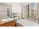 Bathroom featuring vanity, bathtub with tiled surround, and natural light at 7544 Shangri La Ave, Las Vegas, NV 89147