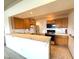 Functional kitchen with wood cabinets, an eat-in bar, and essential appliances at 7570 W Flamingo Rd # 202, Las Vegas, NV 89147