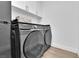 Modern laundry room includes a front-load washer and dryer with storage cabinets at 765 Crimson Peak Pl, Henderson, NV 89011