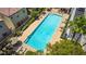 Aerial view of the community pool featuring lounge chairs, palm trees and a nearby building at 7694 Hampton Park Ln, Las Vegas, NV 89113