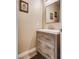 Stylish powder room with modern vanity, rustic wood drawers and a decorative mirror at 7694 Hampton Park Ln, Las Vegas, NV 89113