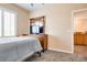 Bedroom featuring dresser with TV, plantation shutters, and ensuite bathroom access at 7694 Hampton Park Ln, Las Vegas, NV 89113