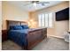 Cozy bedroom featuring a comfortable bed, soft carpet, and a window with white shutters at 7694 Hampton Park Ln, Las Vegas, NV 89113