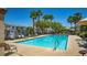 Inviting community pool area with lounge chairs and mature palm trees at 7694 Hampton Park Ln, Las Vegas, NV 89113