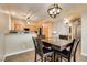 Comfortable dining room with dark wood table and chairs next to kitchen with view of stainless appliances at 7694 Hampton Park Ln, Las Vegas, NV 89113