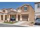 Two-story home with a stone accent front porch, desert landscaping, and a two-car garage at 7694 Hampton Park Ln, Las Vegas, NV 89113