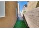 Artificial turf runs along the side of the house with a narrow gate for passage at 7694 Hampton Park Ln, Las Vegas, NV 89113