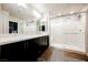 Modern bathroom featuring double sinks, dark cabinets, designer floor tiles, and a glass-enclosed shower at 8113 Misty Canyon Ave, Las Vegas, NV 89113