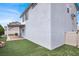 Spacious backyard featuring a covered patio, artificial grass, and stucco walls at 8389 Charlton Valley Ct, Las Vegas, NV 89123
