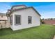 Well-maintained backyard with artificial grass, neutral stucco, and manicured landscaping at 8389 Charlton Valley Ct, Las Vegas, NV 89123