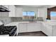 Bright kitchen featuring white cabinets, stainless steel appliances, and mosaic backsplash at 8389 Charlton Valley Ct, Las Vegas, NV 89123