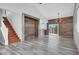 Open-concept living room with wood-look floors, accent walls, and staircase access at 8389 Charlton Valley Ct, Las Vegas, NV 89123