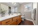 Bathroom features wood flooring and cabinetry, white countertops, and a large mirror above the sink at 8780 Autumn Wreath Ave, Las Vegas, NV 89129