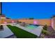 Inviting backyard oasis featuring a modern pool with a waterfall, lush landscaping, and ambient lighting at 8956 Skye Treeline St, Las Vegas, NV 89166