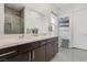 A modern bathroom boasts dual sinks, dark cabinetry, a large mirror, and a walk-in shower with tile surround at 8956 Skye Treeline St, Las Vegas, NV 89166