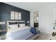 A stylish bedroom showcases contemporary decor, a comfortable bed, and a peek into the ensuite bathroom at 8956 Skye Treeline St, Las Vegas, NV 89166