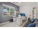 Well-lit home office with a large window, modern desk setup, and comfortable seating area at 8956 Skye Treeline St, Las Vegas, NV 89166
