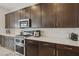Gourmet kitchen with stainless steel appliances, dark wood cabinets, and white countertops for a sleek design at 8956 Skye Treeline St, Las Vegas, NV 89166
