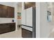 Contemporary kitchen featuring dark cabinets, a white refrigerator, and stylish backsplash, offering a modern design at 8956 Skye Treeline St, Las Vegas, NV 89166