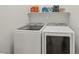 Bright laundry room showcasing modern, white, side-by-side washer and dryer units with storage at 8956 Skye Treeline St, Las Vegas, NV 89166