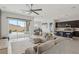 Bright, open-concept living room with a ceiling fan, comfortable seating, and seamless access to the outdoor patio at 8956 Skye Treeline St, Las Vegas, NV 89166