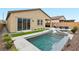 Backyard view showcasing pool with waterfall, artificial turf, and patio furniture at 8956 Skye Treeline St, Las Vegas, NV 89166