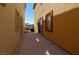 Narrow backyard patio with tan stucco walls, a sliding glass door, and a view of the surrounding mountains at 9209 Tudor Park Pl, Las Vegas, NV 89145